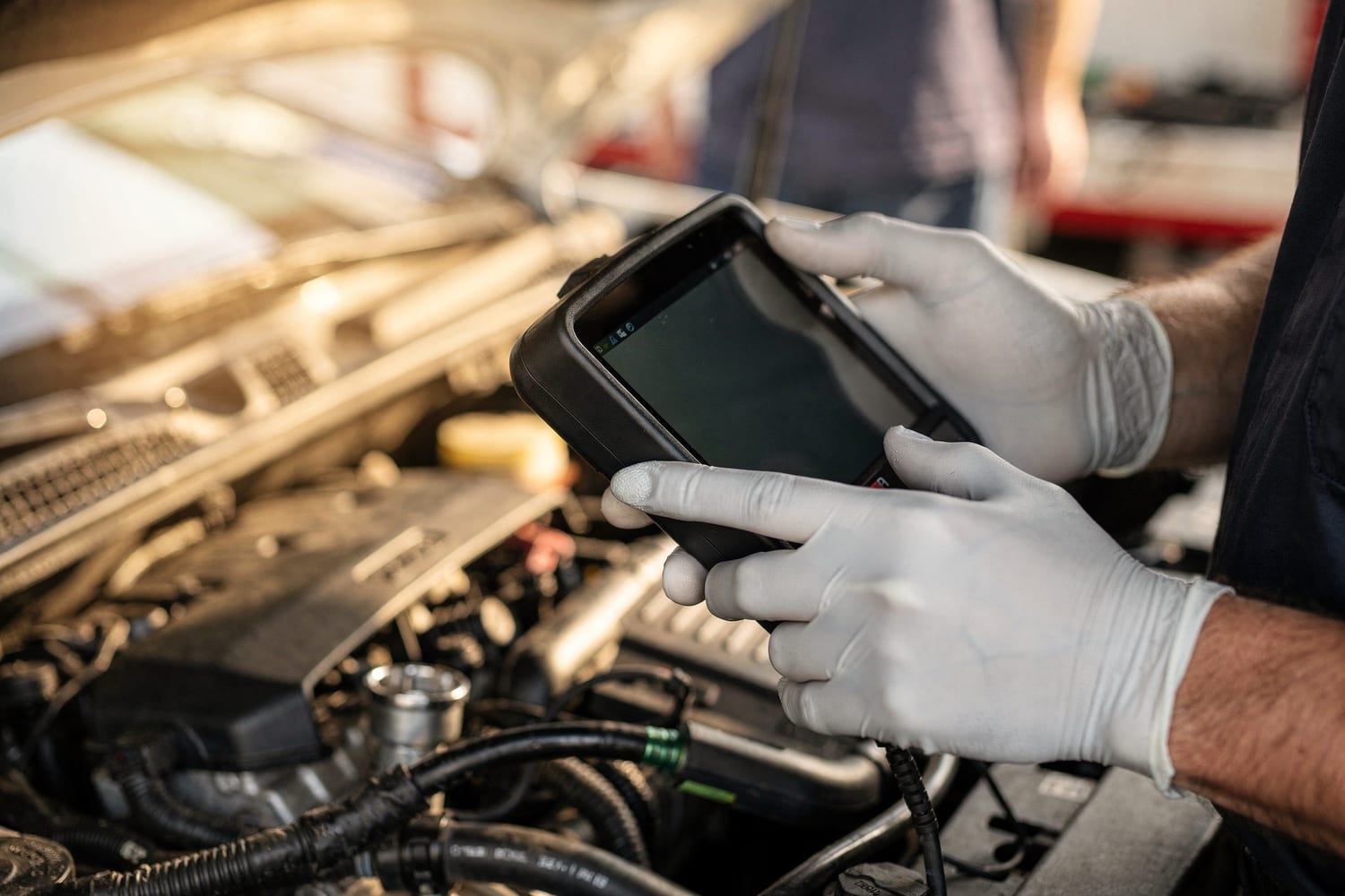 A technician checking a car with a diagnostic scan tool in the shop